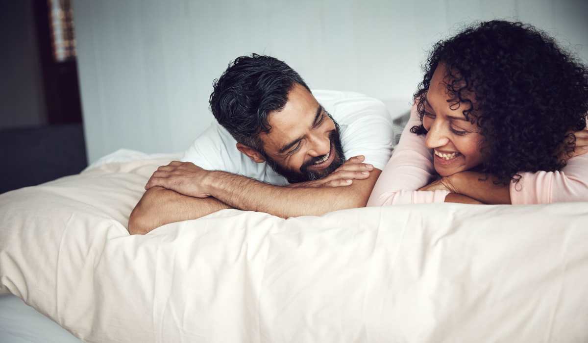 Resident couple chatting on the bed in their new luxury home at Evergreen at River Oaks in Lake Charles, Louisiana