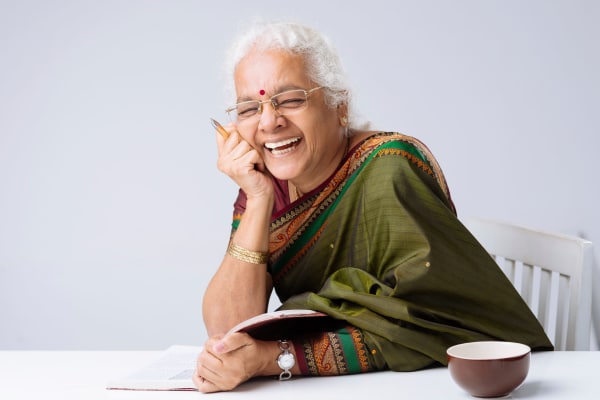 Lady sitting at table with a tea cup laughing at The Retreat at Carolina Bay in Hartsville, South Carolina