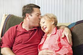 Son giving his mother a kiss on the forehead