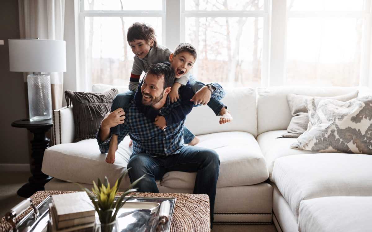 Resident family playing on their couch in their new home at The Grove at Oakbrook in Summerville, South Carolina