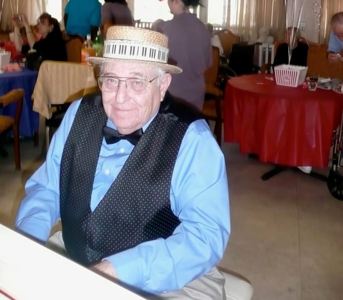 Resident Smiling and sitting near piano