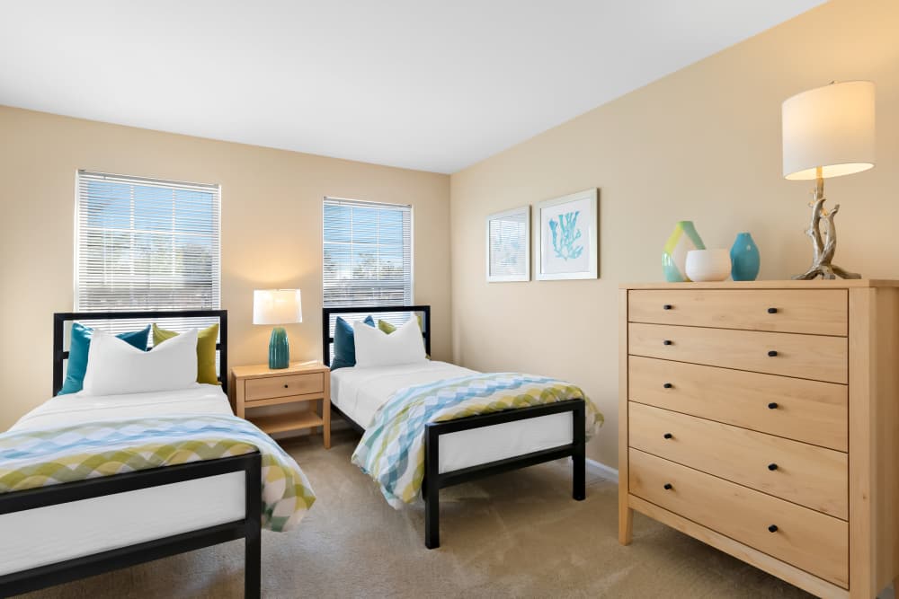 A Wooden Nightstand Sits Between the Beds And Two Windows at Arbor Brook in Murfreesboro, Tennessee