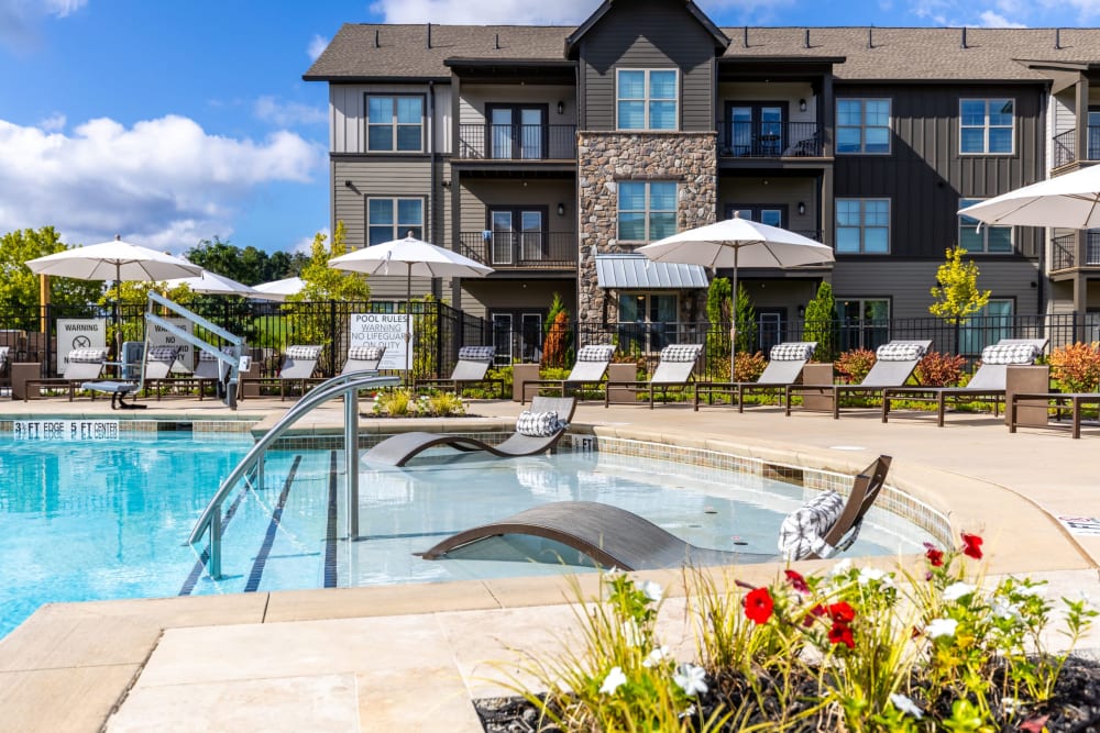Swimming pool with in-pool lounge chairs at The Holston | Apartments in Weaverville, North Carolina