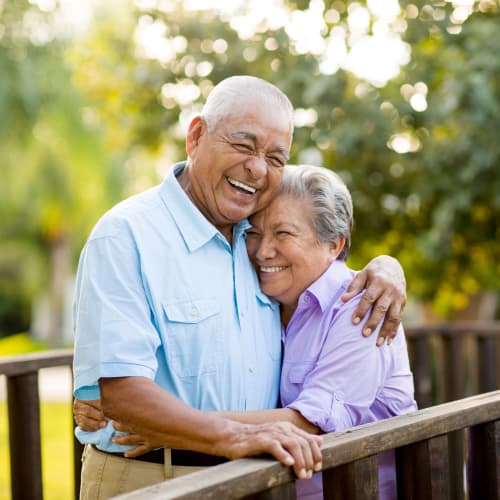 Resident couple hugging outside at The Heritage of Clearlake in Houston, Texas