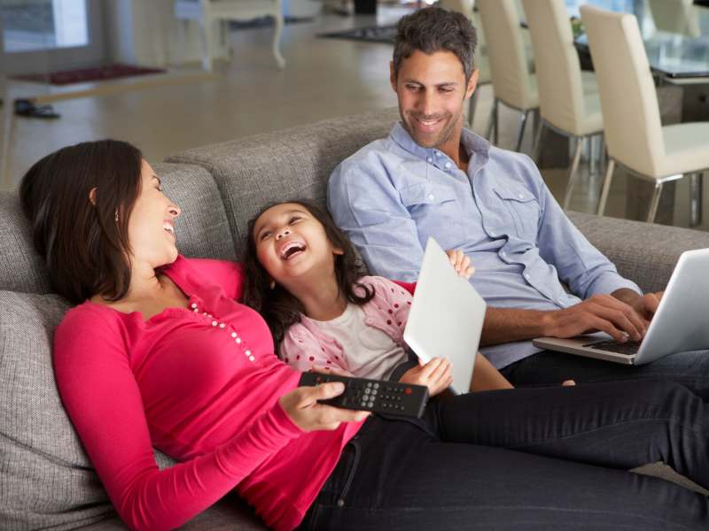 Happy family in their spacious living room at Tarzana Courtyard in Tarzana, California