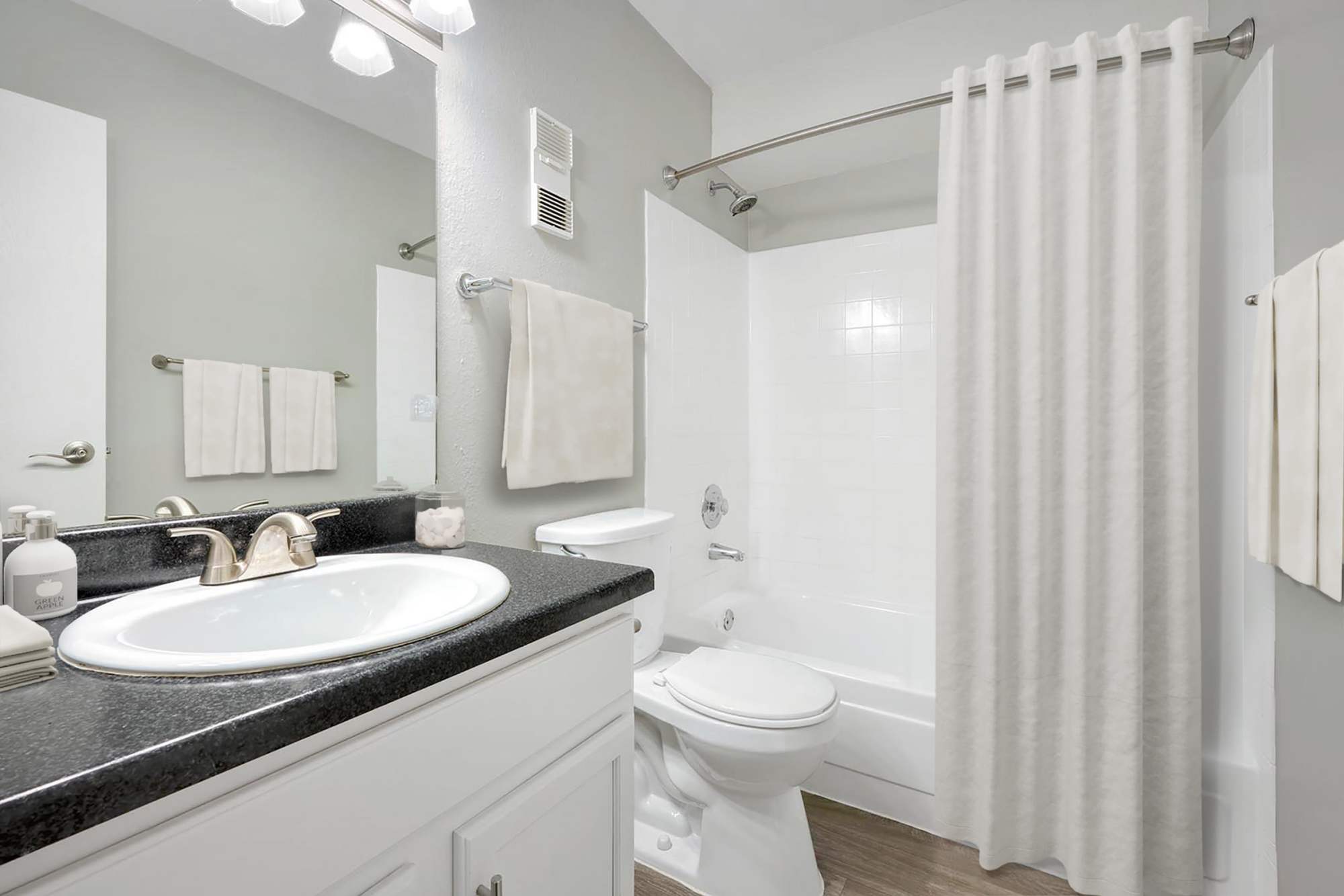 Bright bathroom with black countertops at Ascent at Havana in Denver, Colorado
