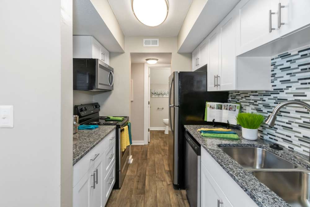 Contemporary kitchen with tile backsplash and white cabinetry at The Preserve on Allisonville in Indianapolis, Indiana