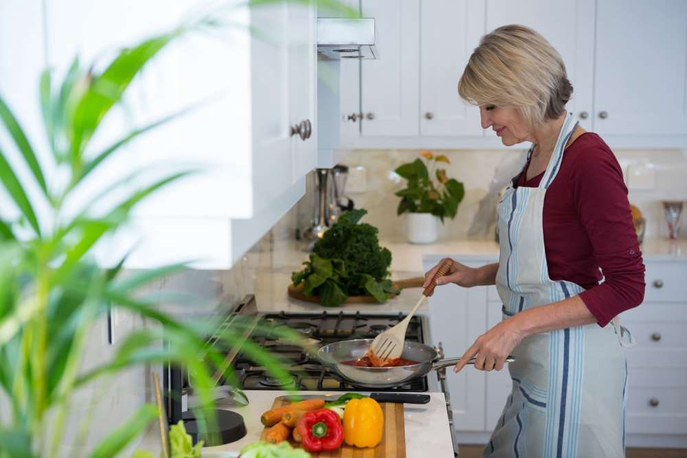 Residnet cooking in her kitchen at Savannah House At Lawton in Lawton, Oklahoma