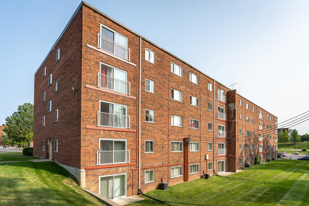 Exterior of the apartment building and multiple cars parked in front of the building at Vantage Pointe West Apartment Homes in Cincinnati, Ohio