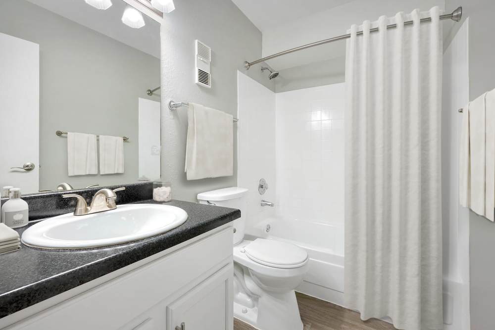 Bathroom with white cabinets and a tub at Ascent at Havana in Denver, Colorado