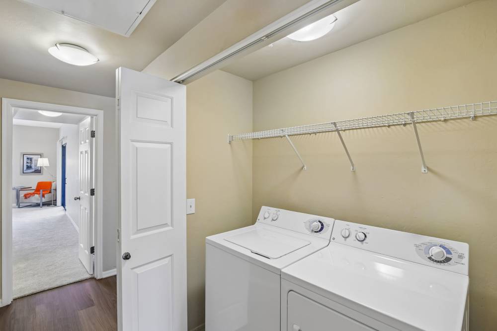 Laundry closet with white stacked or side-by-side washer and dryer at Oro Vista Apartments in Oro Valley, Arizona