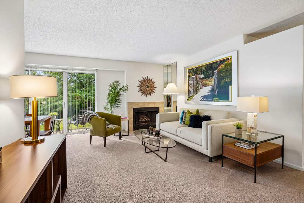 Stylish model living room with a gas fireplace and sliding door access to a private patio at Briar Cove Terrace Apartments in Ann Arbor, Michigan