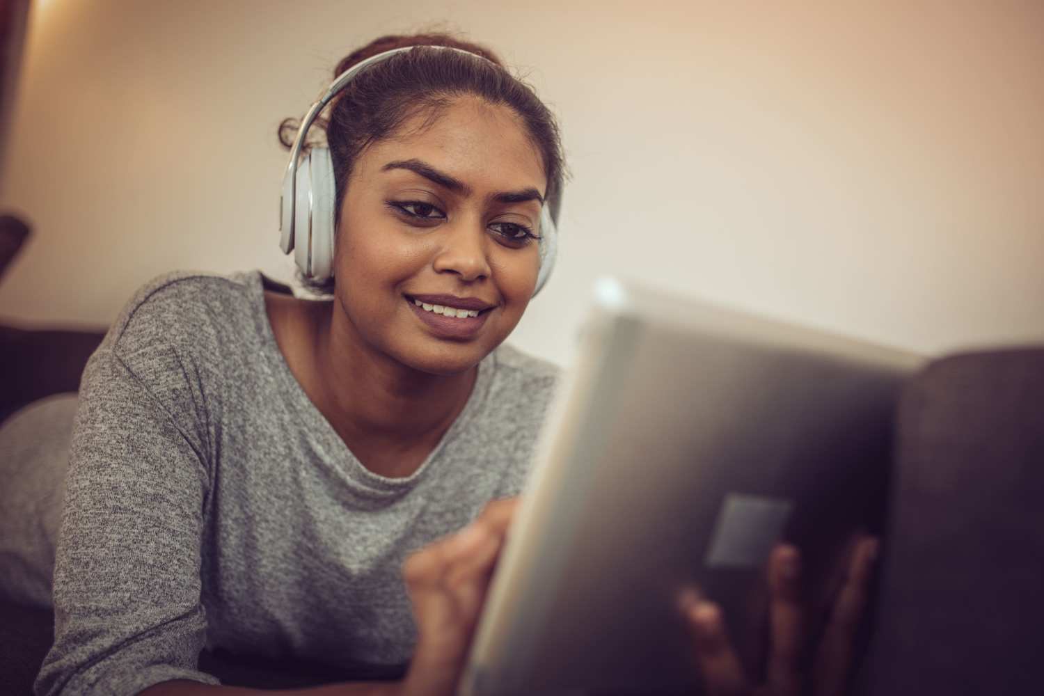 A young woman using the resident portal on her tablet at Crown Pointe Villas in Cromwell, Indiana