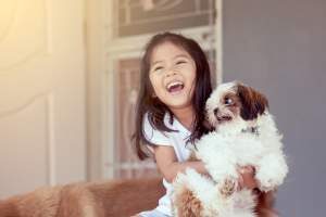 Joyful child embracing her furry pet at Copper River in Spokane, Washington