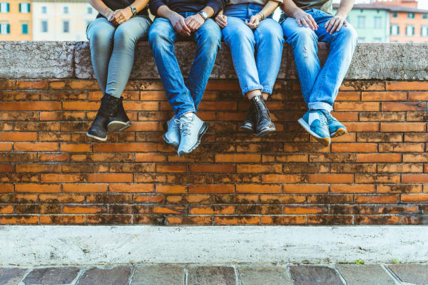 Four friends sitting on a brick wall near Parkside Towns in Richardson, Texas