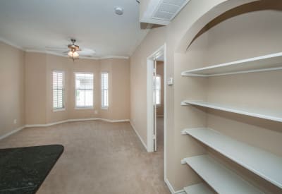 Ceiling fan and built-in bookshelves in open-concept floor plan at Rosemont at Olmos Park in San Antonio, Texas