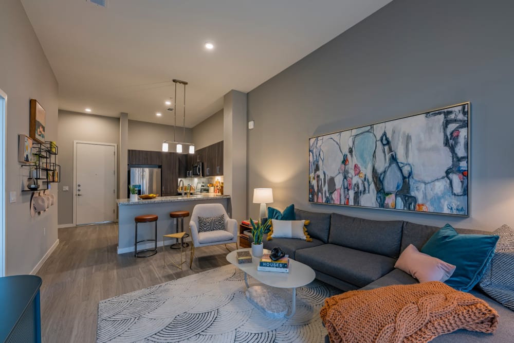 A spacious living room with wood-style flooring at The Tessera in Phoenix, Arizona