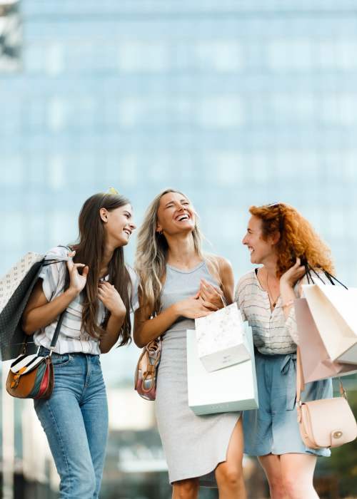 A group of happy women holding shopping bags outside near The Mill at Westside in Atlanta, Georgia