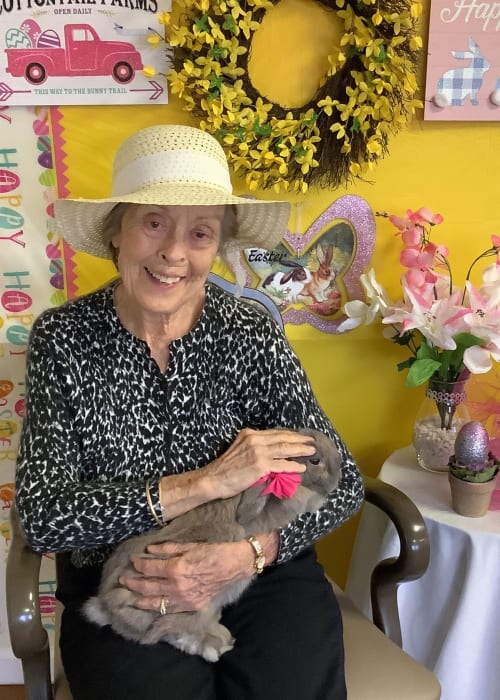 Resident holding a bunny at an Easter event at Grand Villa of Delray West in Delray Beach, Florida