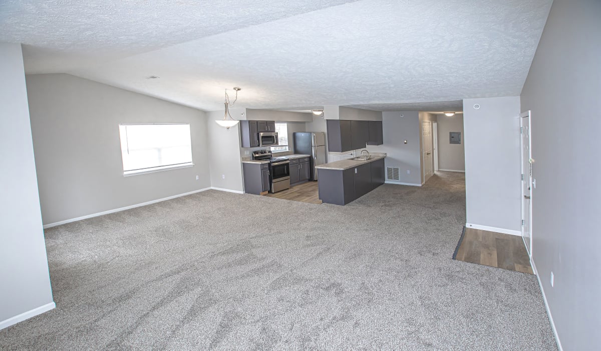 A large living with plush carpeting at Silver Lake Hills in Fenton, Michigan