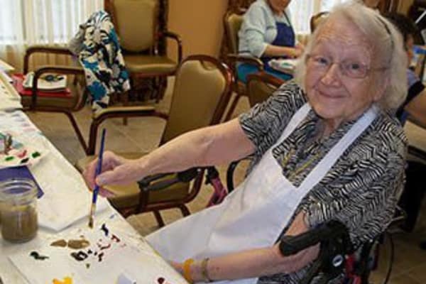 Woman paints at memory care at Discovery Commons At Spring Creek in Garland, Texas