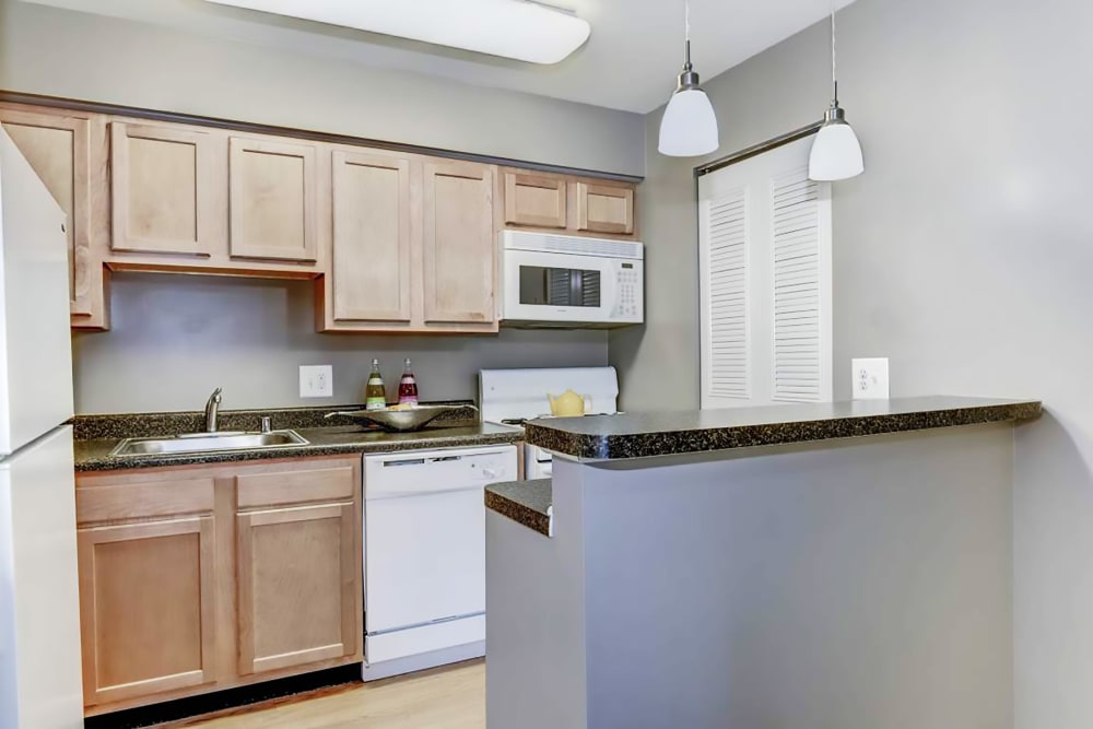 Model kitchen with bar seating at Hampton Manor Apartments & Townhomes in Cockeysville, Maryland
