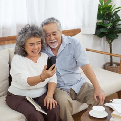 A couple sitting on the couch and having a cup of coffee at Westmont Village in Charlotte, North Carolina