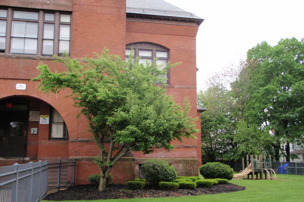 Playground equipment near brick building at Bh Tapley Court in Springfield, Massachusetts