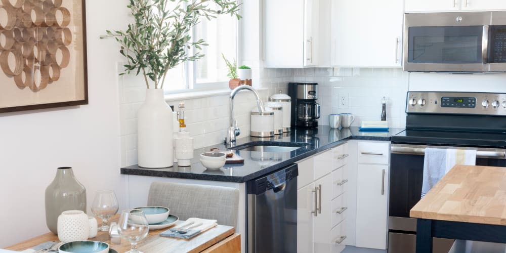 Kitchen with a subway tile backsplash and adjacent breakfast nook in a model home at The Bixby in Washington, District of Columbia
