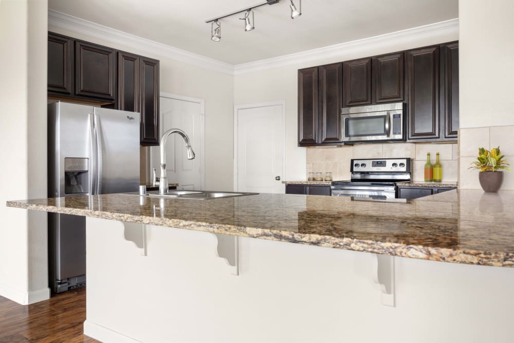 Granite countertops in a model home's kitchen at Olympus Woodbridge in Sachse, Texas