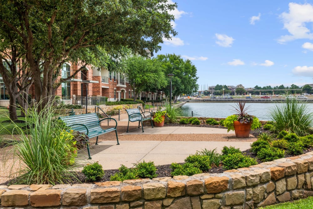 Beautifully maintained landscaping and green spaces outside resident buildings at Olympus Las Colinas in Irving, Texas