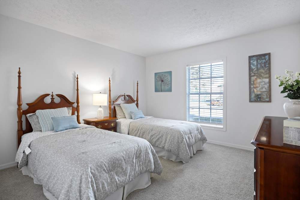 Modern bedroom with two twin beds featuring wooden headboards at Carlton Arms Of South Lakeland in Lakeland, Florida