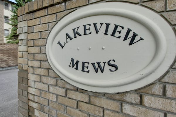 Close-up of a brick wall with a Lakeview Mews sign in Calgary, AB