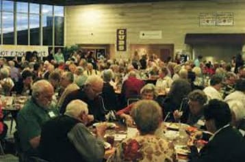 Overcrowded tables of seniors eating dinner