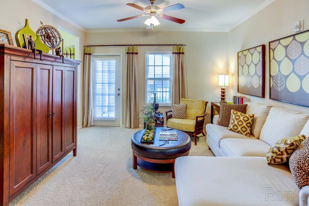 Living room with a couch and windows at Highland Hills Apartments in Dothan, Alabama