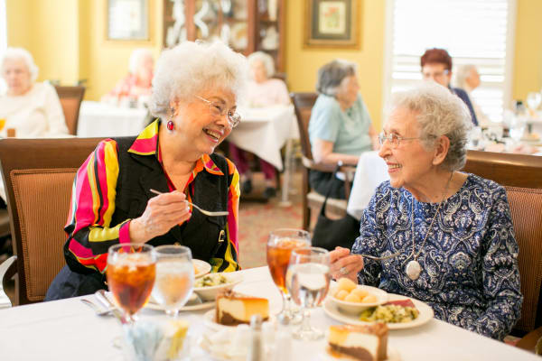 Two residents smiling while dining at Wesley Gardens in Montgomery, Alabama