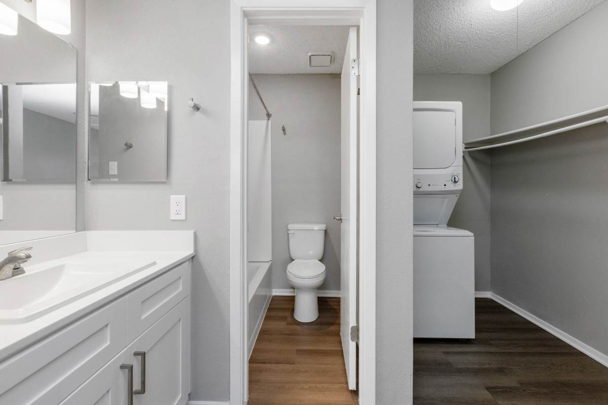 Model bathroom and laundry closet with stacked washer and dryer at Hunters Glen in Killeen, Texas
