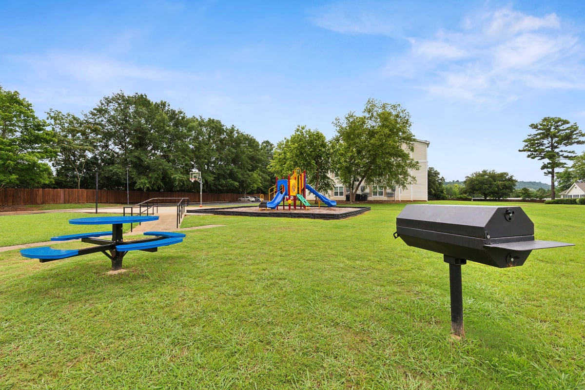 Grilling and picnic area nearby outdoor playground and basketball court at Barrington Parc in Moody, Alabama