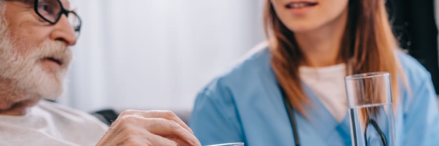 Resident being assisted with taking medication at Holton Manor in Elkhorn, Wisconsin