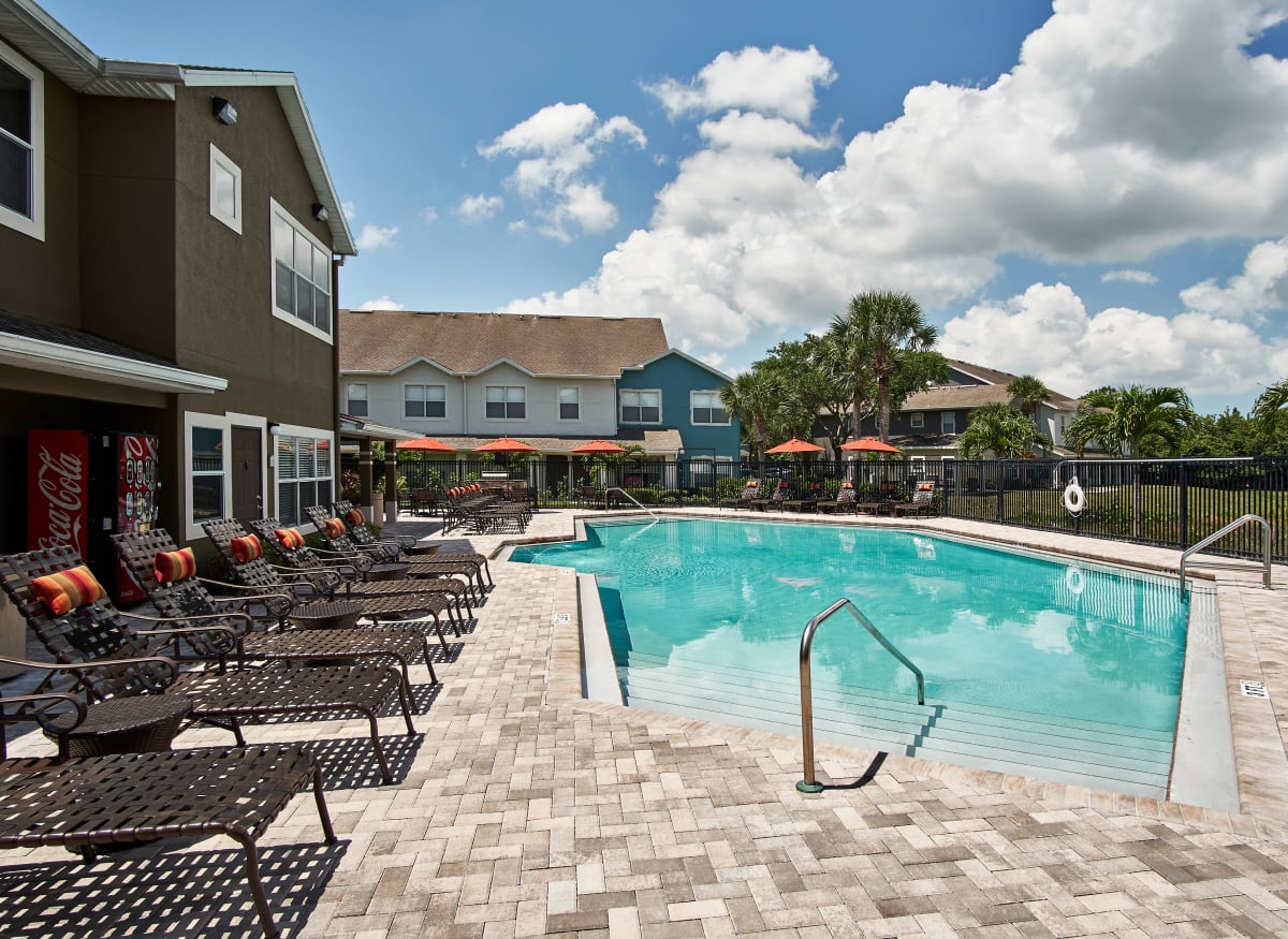 A swimming pool with lounge chairs at Calais Park Apartments in St Petersburg, Florida