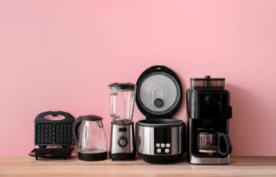 kitchen appliances against a pink wall on wooden counter