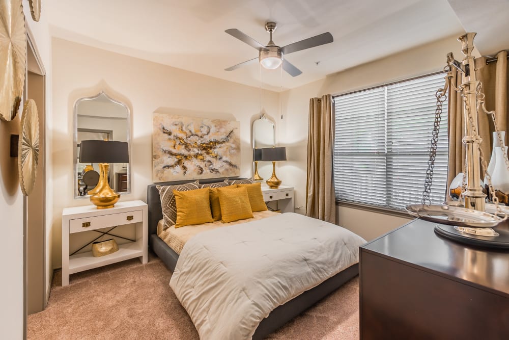 Furnished model apartment with art on the walls, several standing lamps, and stainless steel appliances at Haven at Lewisville Lake in Lewisville, Texas.