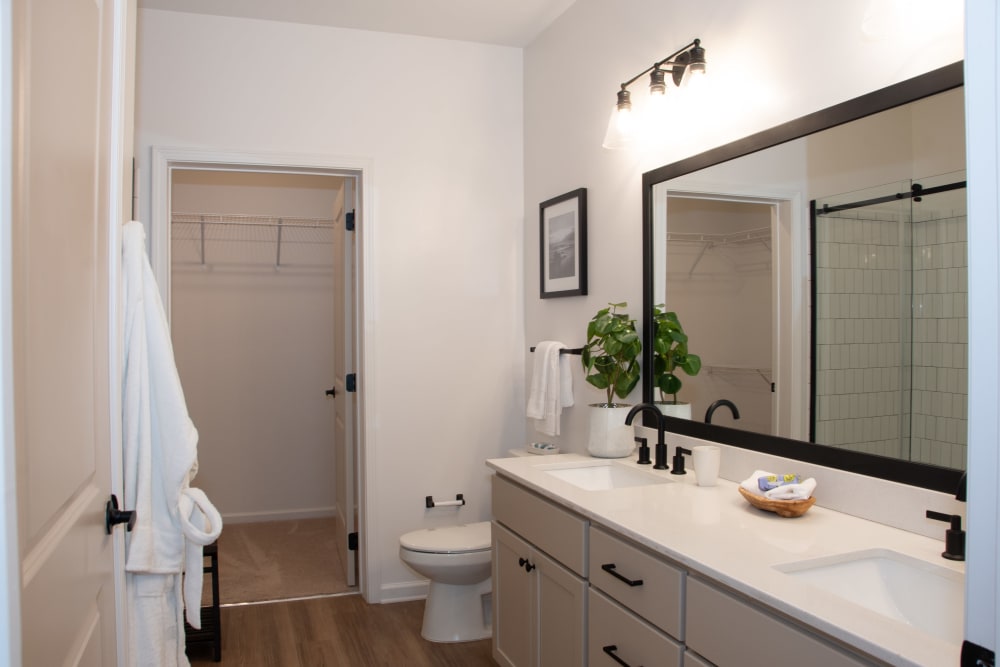 Model bathroom with a double vanity and walk-in closet at Primrose at Santa Rosa Beach in Santa Rosa Beach, Florida