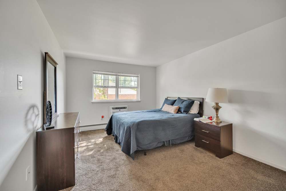 Vibrant bedroom with windows, mirror and lamp at Ridgeview Apartment Homes in Reading, Pennsylvania
