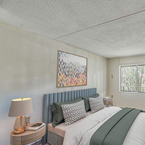 Model bedroom with large window at The Grove in Ontario, California