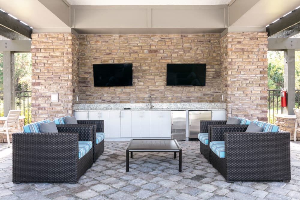 Outdoor lounge with comfortable seating and TVs at Integra 289 Exchange in DeBary, Florida