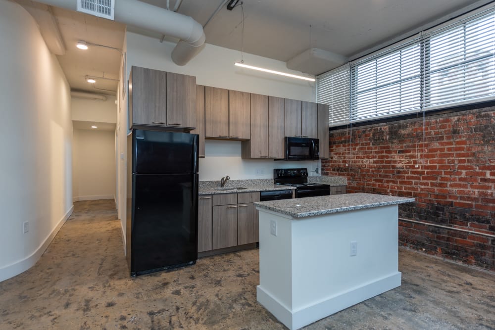 Updated kitchen with exposed brick walls at The Oliver in Richmond, Virginia