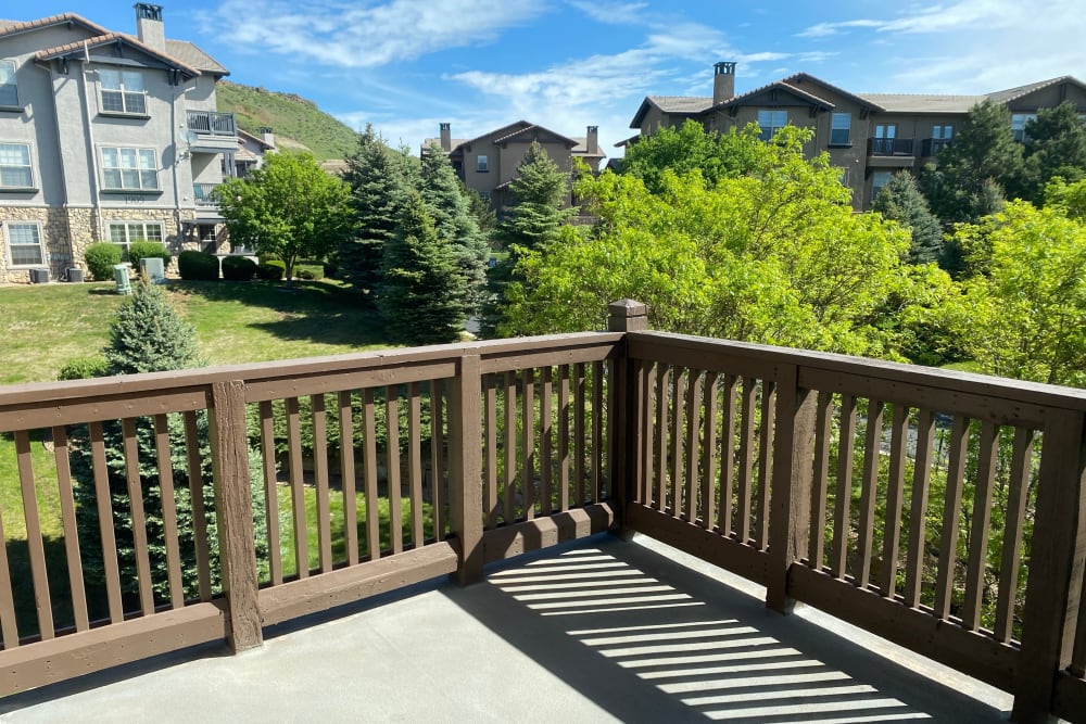 Private balcony overlooking beautifully landscaped grounds with mature trees at Montrachet Apartment Homes in Lakewood, Colorado