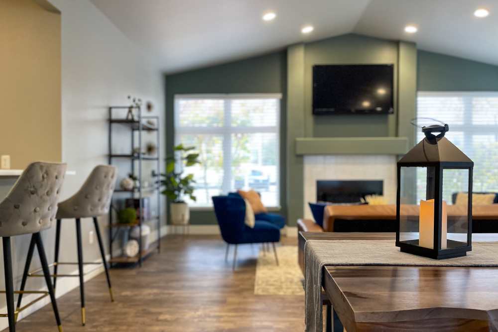 Upscale and large resident lounge with couches, tables, and flat screen television at Briarstone in Tacoma, Washington