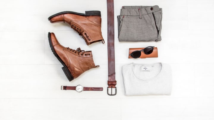 Shoes, watch, belt, pants, glasses and sweater lying on white floor | Unsplash